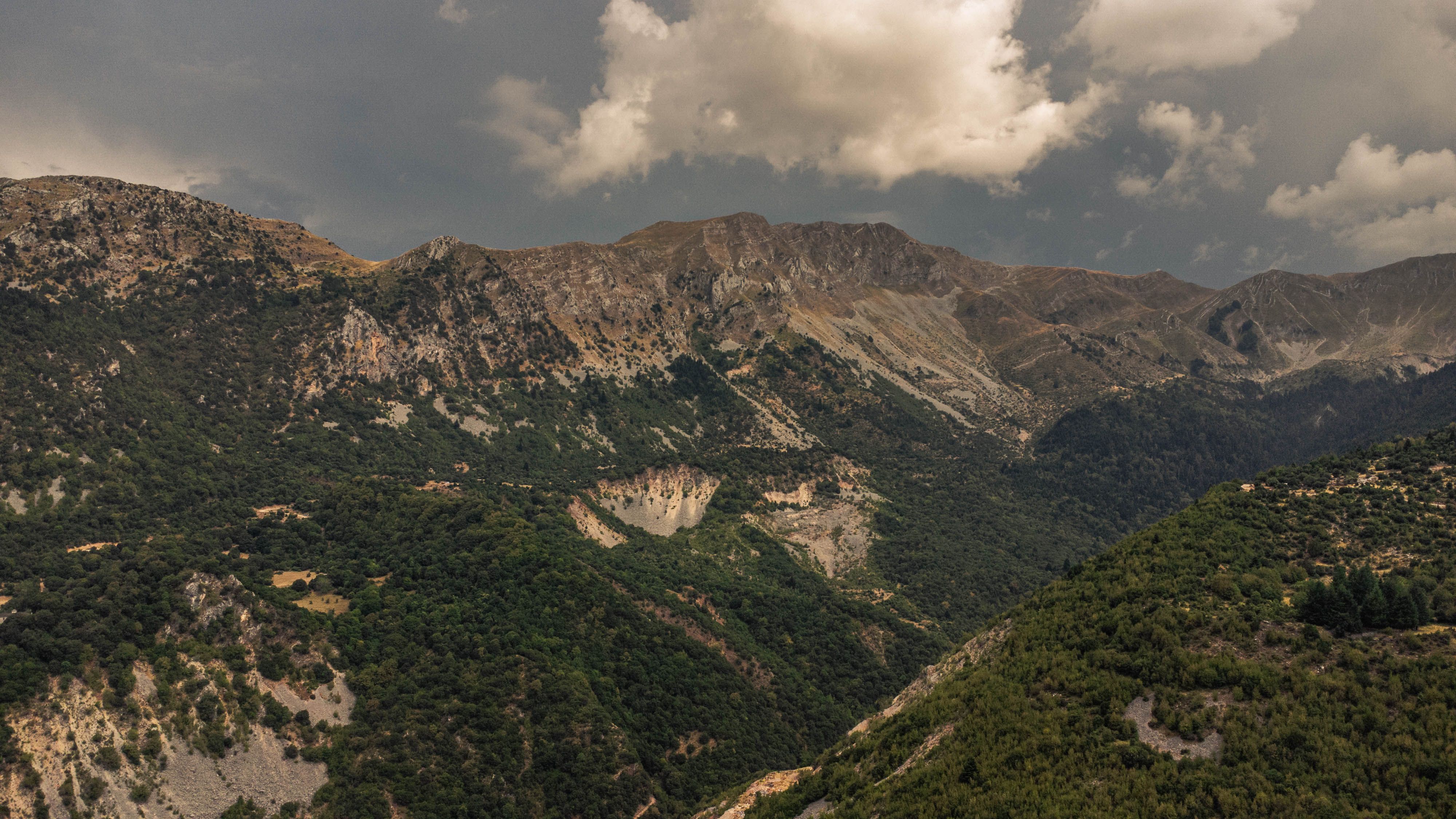 Stunning aerial view of rugged Pindus Mountains under a cloudy sky in Greece.