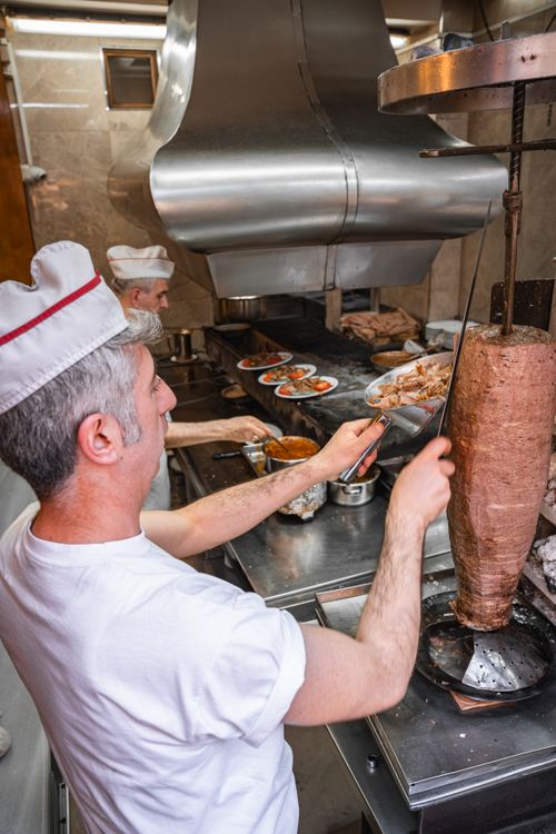 Free Two chefs preparing traditional Turkish döner kebab in a bustling Bursa kitchen. Stock Photo