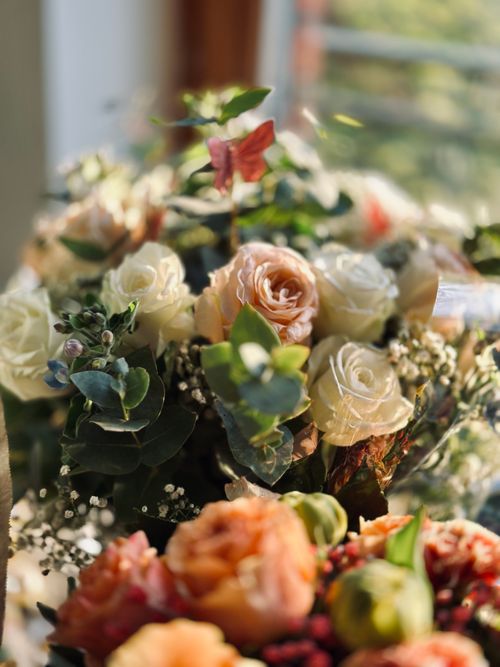 Free Beautiful bouquet featuring white and peach roses with greenery, softly lit. Stock Photo