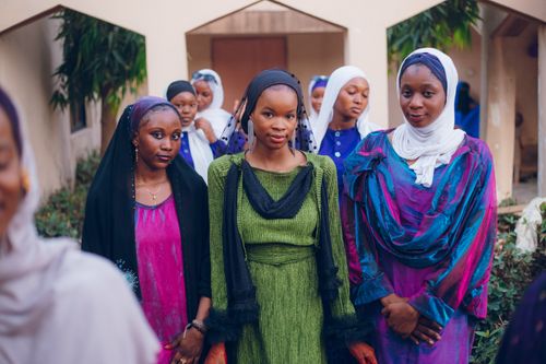 Free A group of women in colorful traditional dresses gathered outdoors, showing cultural beauty. Stock Photo