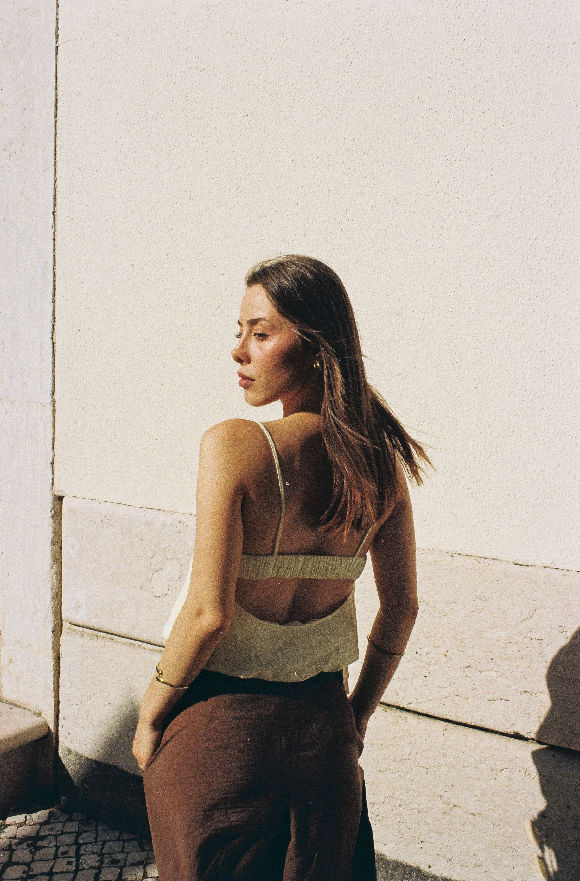 Elegant portrait of a woman in Lisbon, embracing the warmth and fashion of a sunlit day.