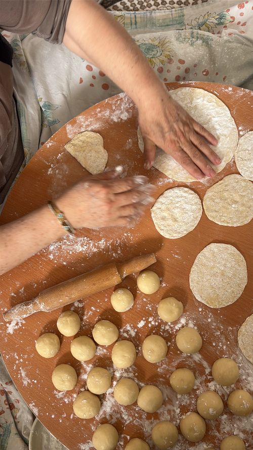 Free A person crafting homemade dough circles on a floured surface, showcasing traditional Turkish cooking. Stock Photo