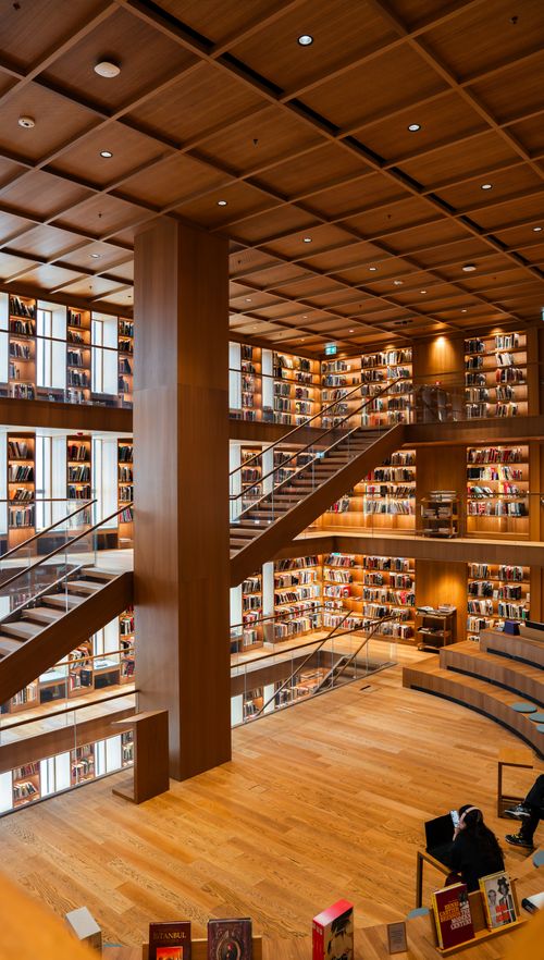 Free Spacious modern library interior with a wooden staircase and sleek bookshelves in İstanbul, Türkiye. Stock Photo