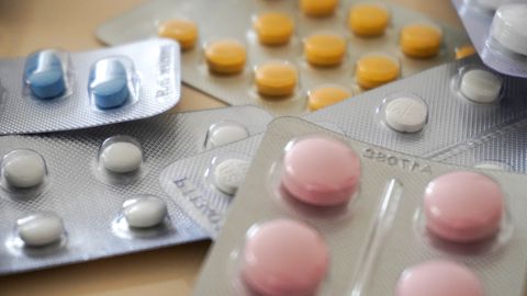 Close-up view of assorted colorful medication blister packs with diverse pills.