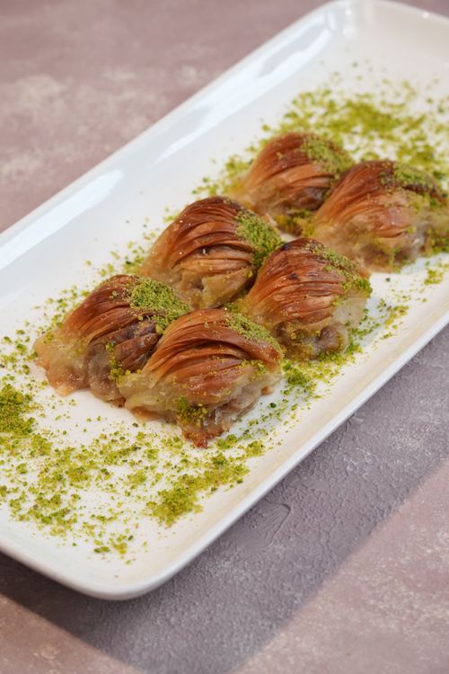 Free Tasty baklava on a plate, topped with crushed pistachios, perfect for dessert lovers. Stock Photo