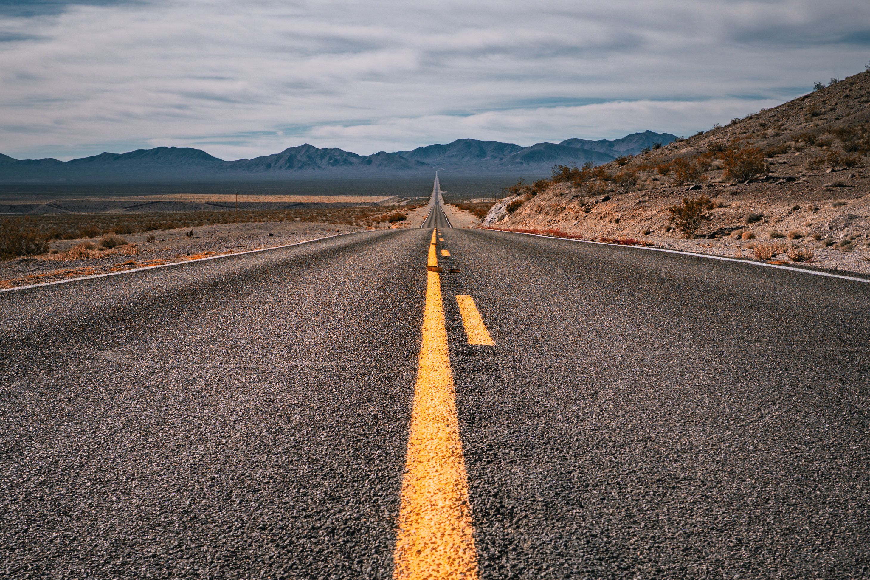 A straight highway through an arid desert landscape.