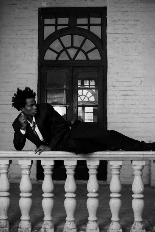 Free Artistic black and white photo of a man posing on a balcony in Lagos, Nigeria. Stock Photo