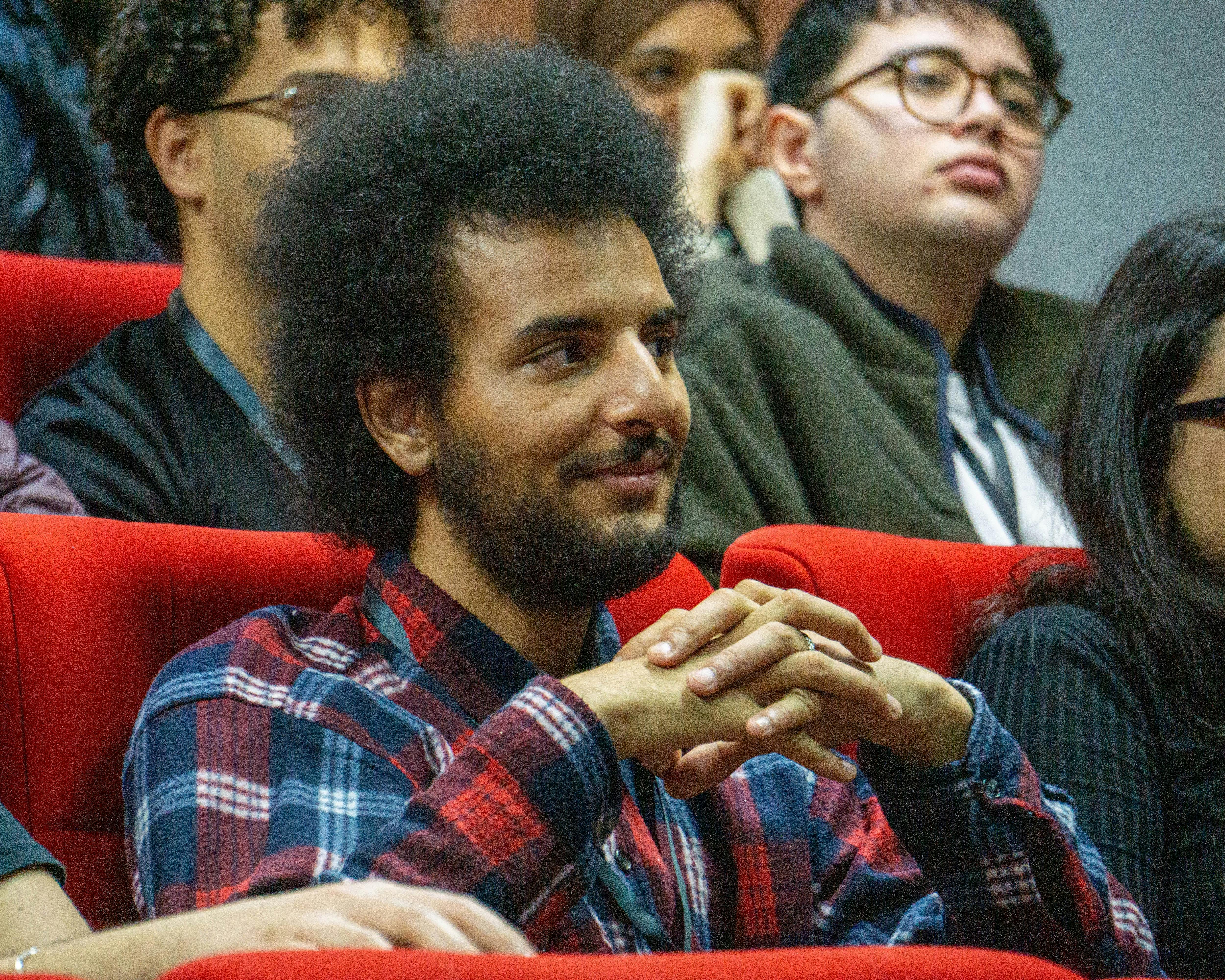 Attentive individual in a lecture hall setting, showing interest in the presentation.