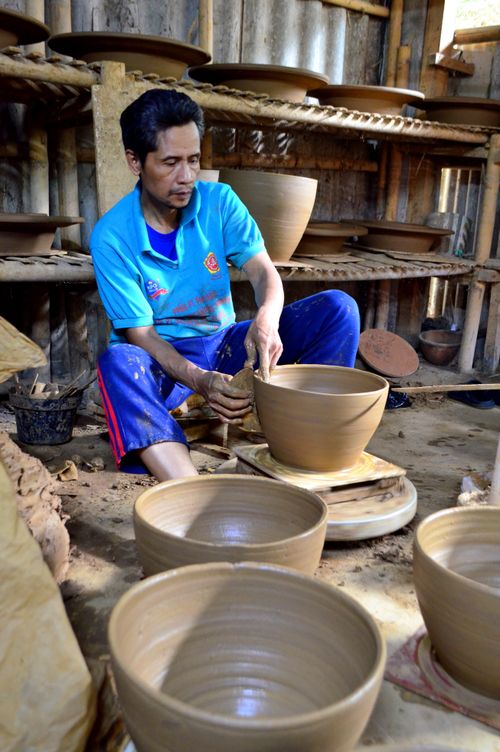Free Skilled artisan shaping clay pottery in a traditional workshop in West Java, Indonesia. Stock Photo
