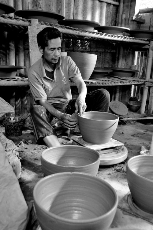Free Artisan skillfully shapes clay pot on wheel in rustic workshop, showcasing traditional pottery techniques. Stock Photo