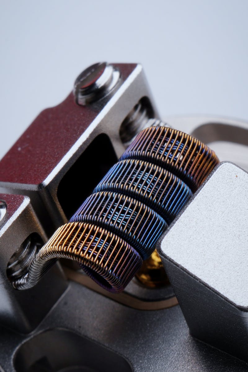 Closeup of fused clapton coil on dripper of modern electronic cigarette on white background