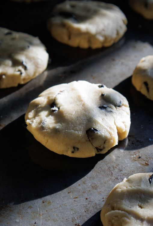 Free Close-up of chocolate chip cookie dough pieces baking on a tray under natural lighting. Stock Photo