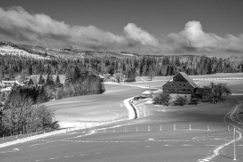 Free Charming winter landscape of the Swiss countryside with snow-covered fields and rustic cabin. Stock Photo
