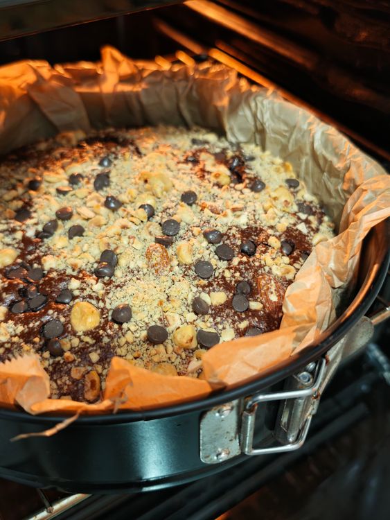 Free A delicious chocolate cake with nuts baking in the oven, complete with chocolate chips on top. Stock Photo