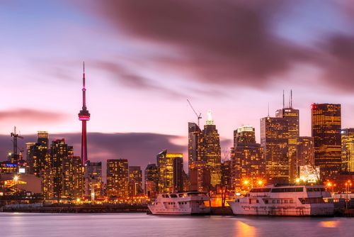 Free Vibrant Toronto cityscape at sunset featuring CN Tower and waterfront. Stock Photo