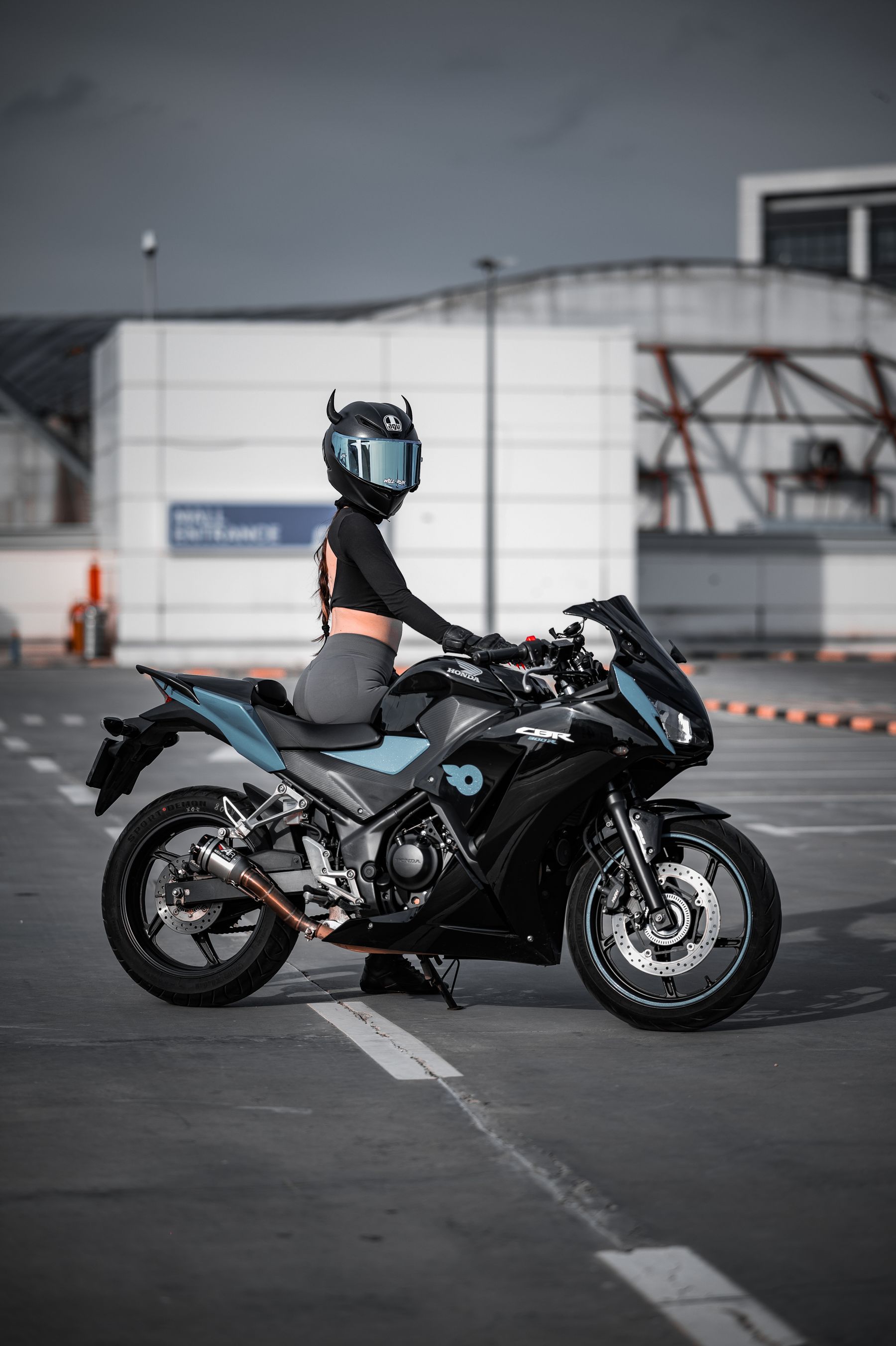 Helmeted motorcycle rider with a sport motorcycle in an urban environment