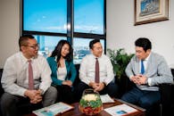 Business People in Formal Wear Sitting on Sofa Smiling and Talking