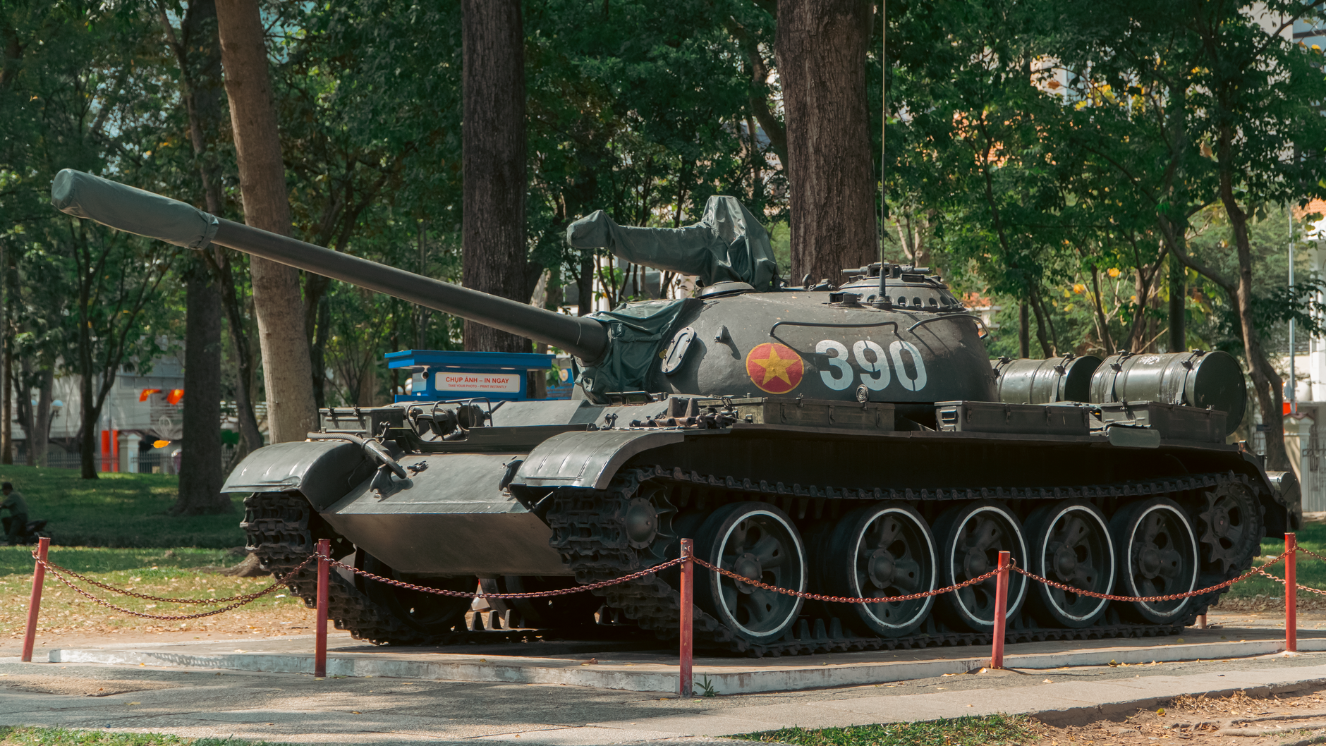 A vintage tank featuring the number 390, displayed outdoors in a park setting.