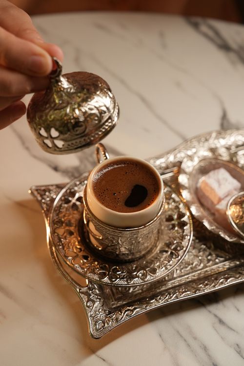 Free Elegant presentation of Turkish coffee with ornate silverware and Turkish delight. Stock Photo