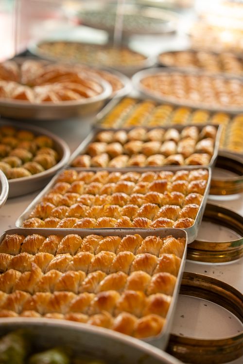 Free Rows of freshly made baklava are beautifully presented in trays, highlighting their golden, crispy layers. Stock Photo