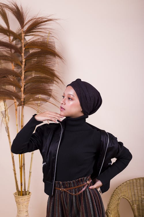 Woman in Black Hijab Posing Near Dried Plants