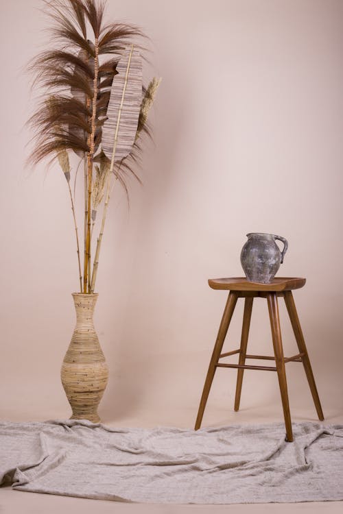 藍色陶瓷花瓶棕色木凳上的棕色植物