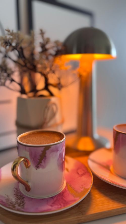 Free Stylish coffee setup with decorative cups and gentle lamp glow, creating a cozy atmosphere. Stock Photo