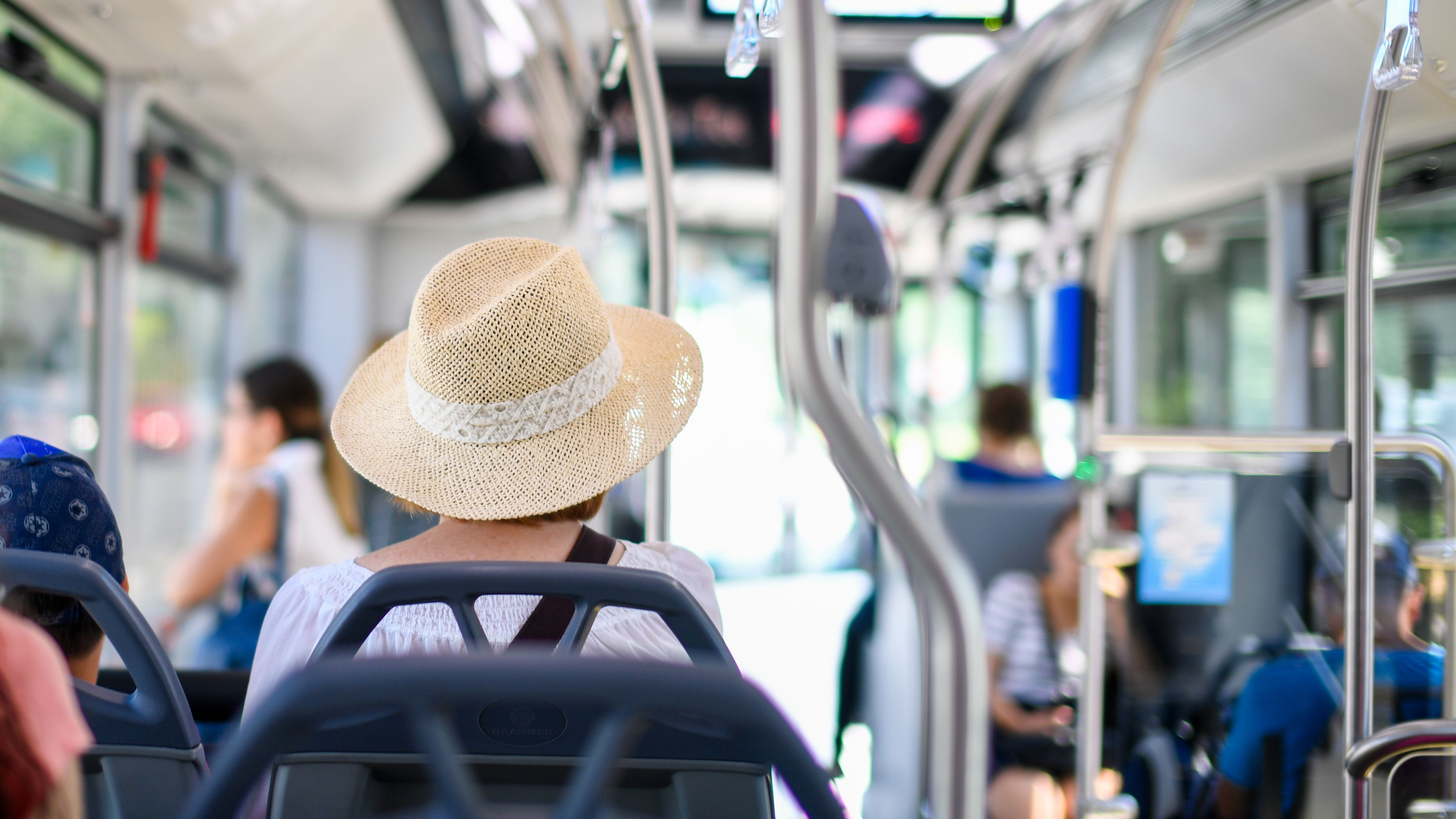 Passenger wearing straw hat on a sunny bus ride · Free Stock Photo