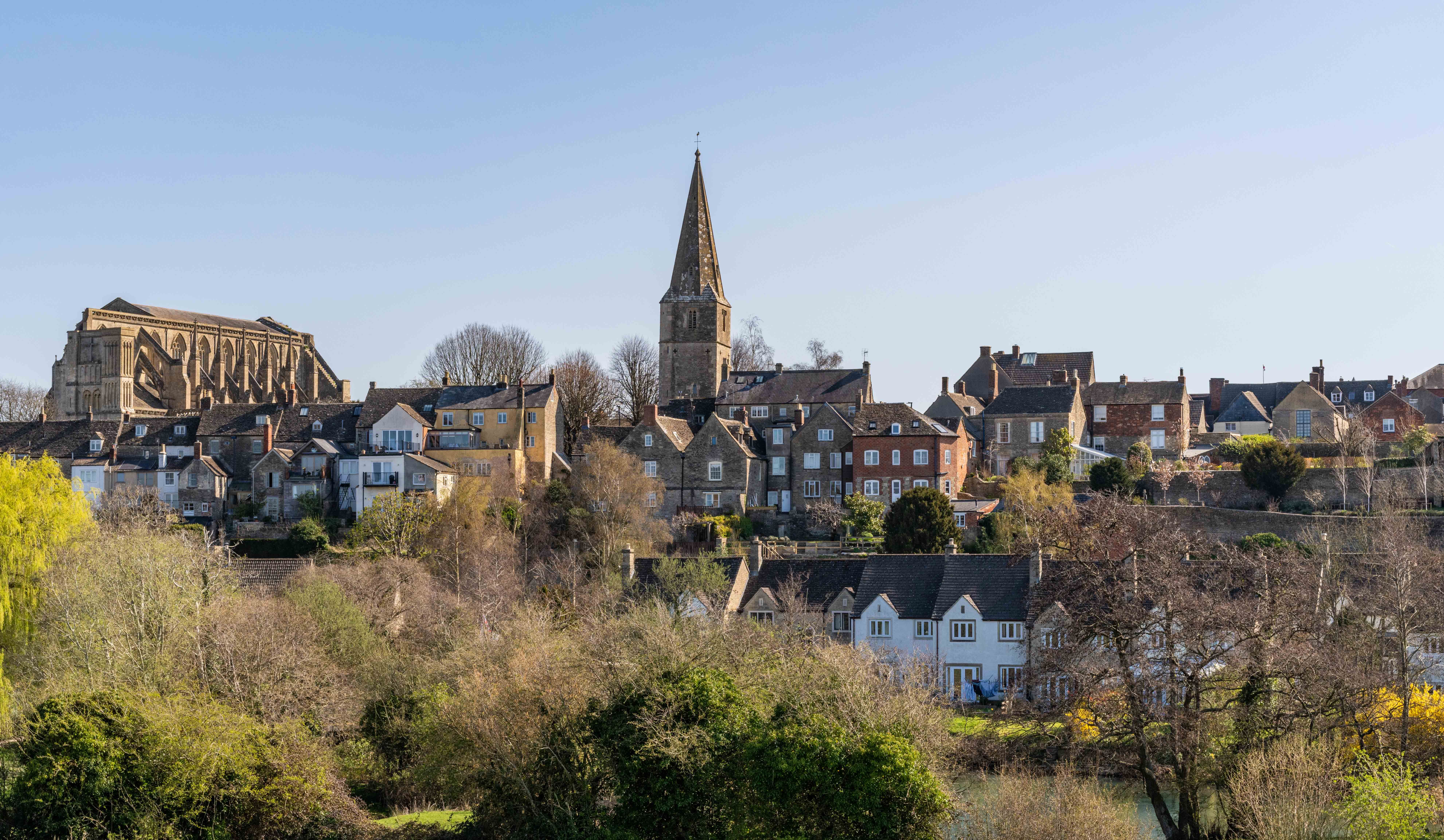 Scenic view of a picturesque English village with a historic church and traditional houses.