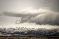 冬季雷暴的天空下，覆盖着白雪的粗犷山脉展现出令人叹为观止的景观
