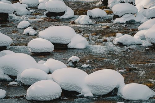 Free Amazing view of calm river with stones covered with snow in winter during daytime Stock Photo