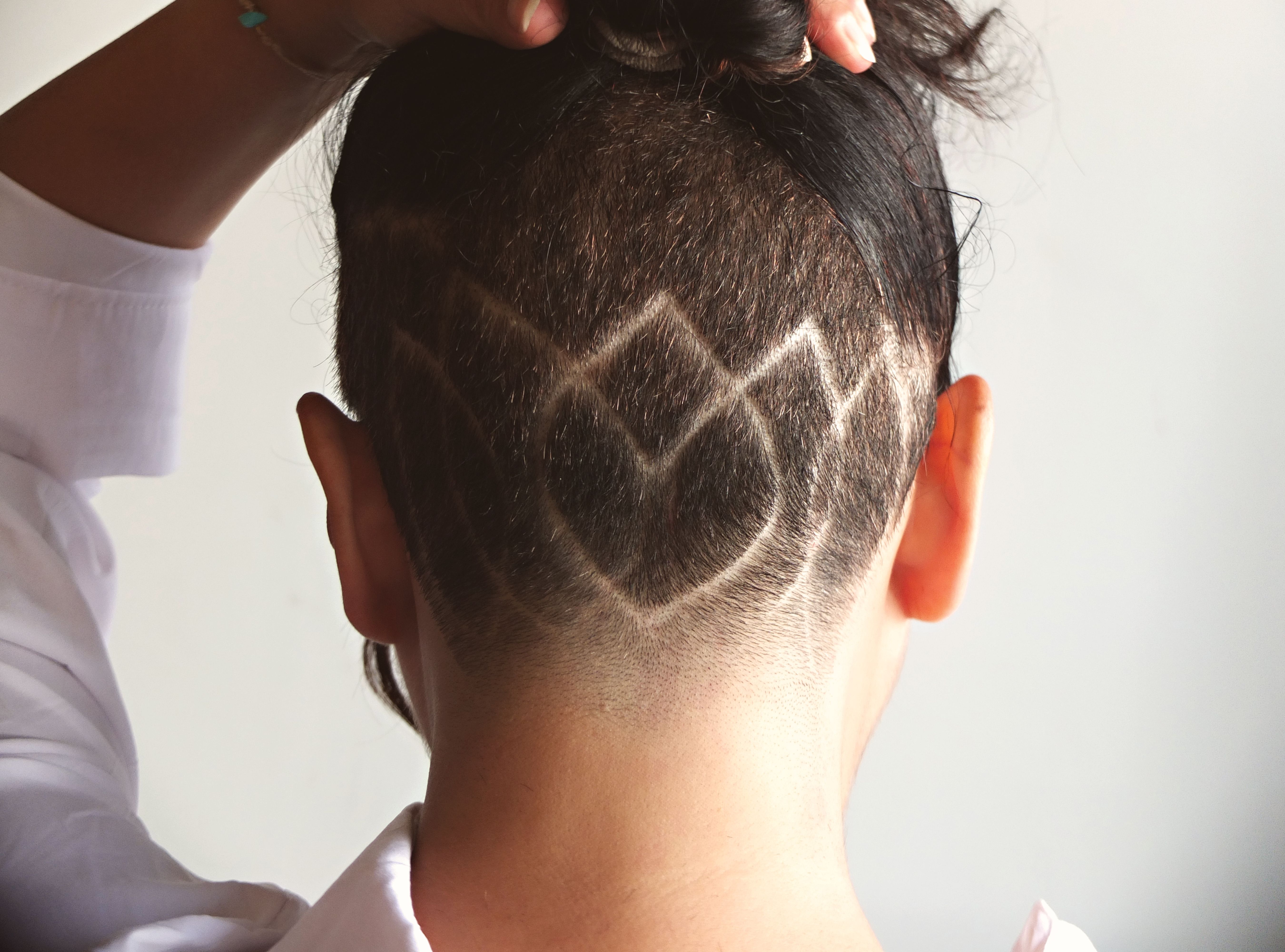 Close-up of a geometric undercut hairstyle with intricate patterns, showcasing unique fashion style.