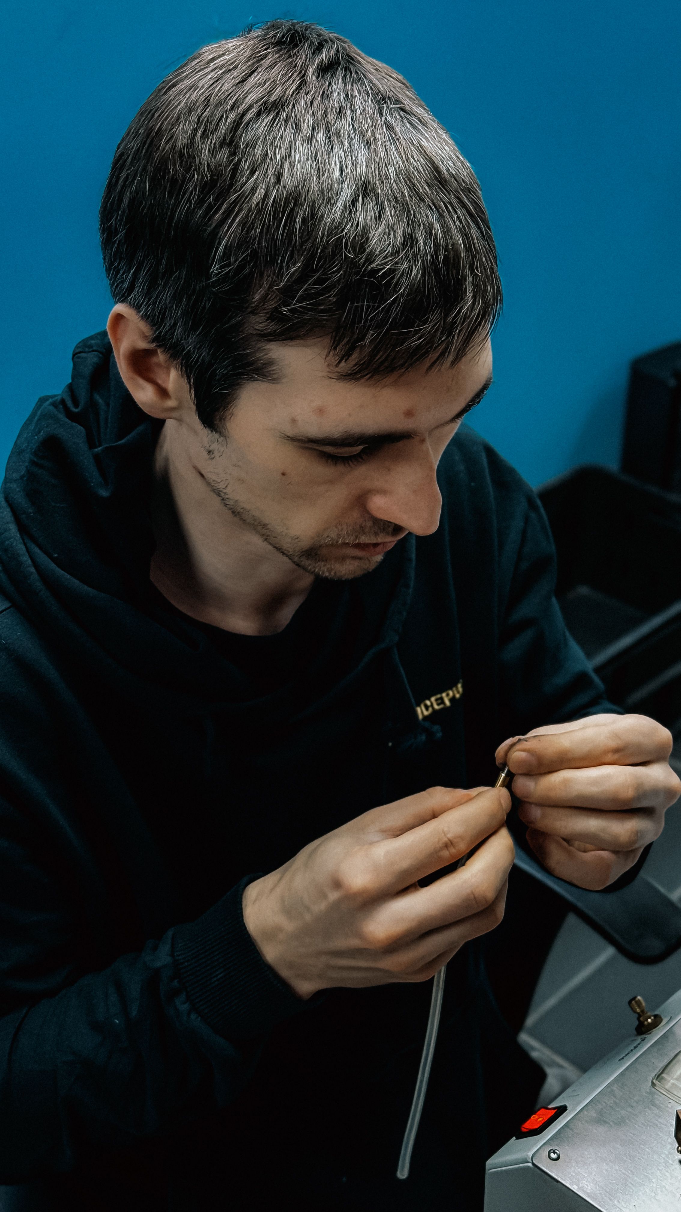 Professional focused on detailed wiring work in a tech workshop.