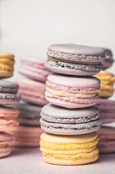 桌上堆放着一盘色彩缤纷的什锦马卡龙，特写镜头下显得格外美味