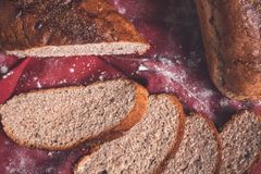 A rustic arrangement of freshly baked bread with slices on a red cloth, showcasing a warm, artisanal look.