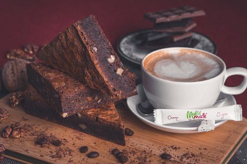 Free Appetizing chocolate brownie and mug of hot cappuccino served on wooden cutting board in cafe Stock Photo