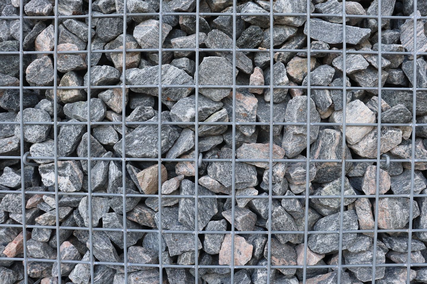 Detailed view of a gabion retaining wall filled with tightly packed natural stones in Cambridge, Ontario. Detailed view of a gabion retaining wall filled with tightly packed natural stones in Cambridge, Ontario.