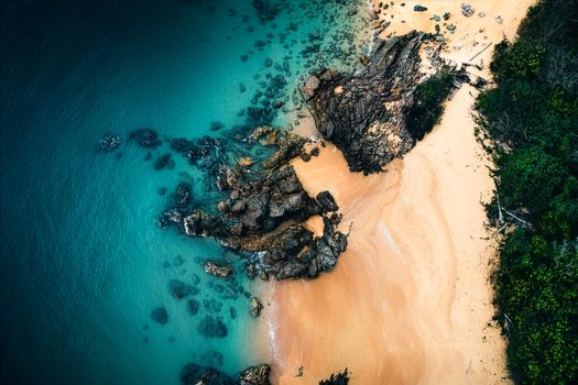 Stunning aerial photograph capturing a rocky coastline and turquoise waters.