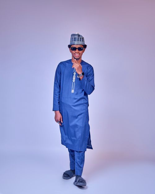 Free Stylish man in blue traditional Nigerian attire poses confidently indoors. Stock Photo