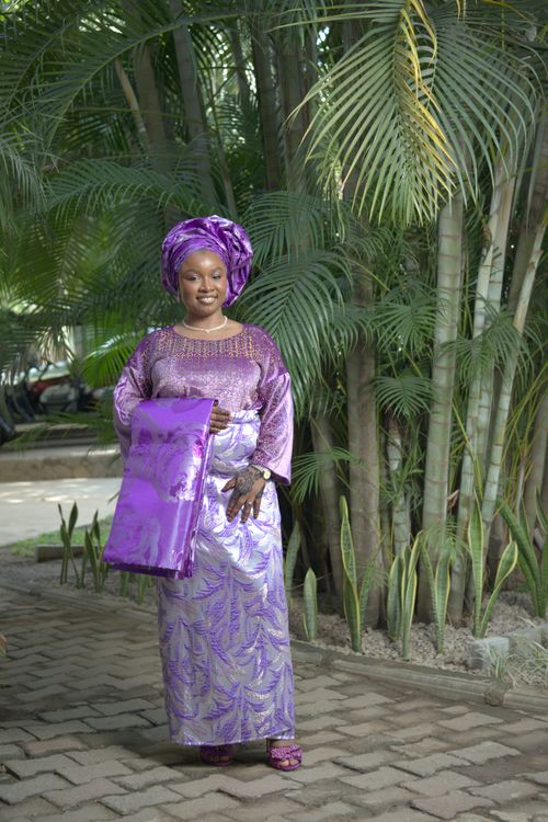 Free Woman in vibrant purple Nigerian dress and headwrap outdoors. Stock Photo