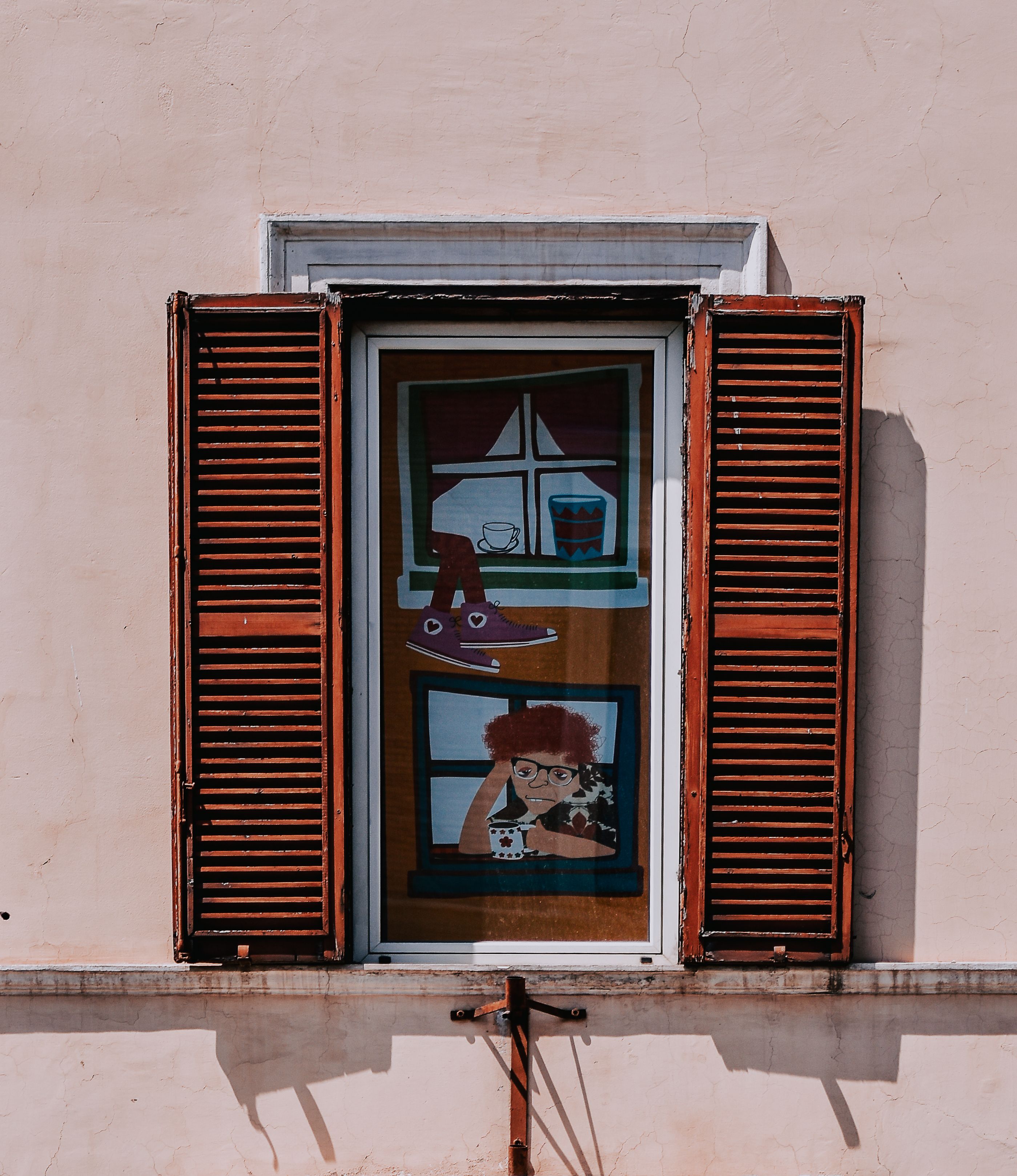 Free Wooden shutters on a window frame colorful artwork, creating a unique visual aesthetic. Stock Photo