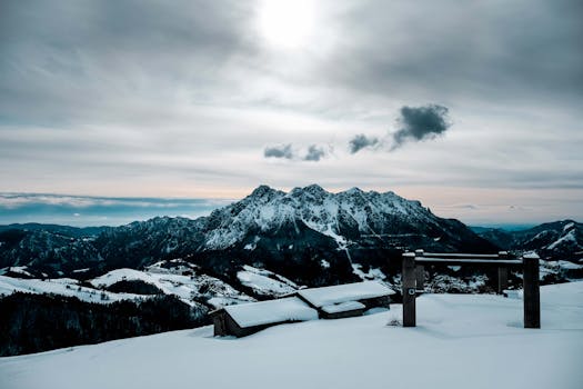 Breathtaking view of snow-covered mountains with a cloudy sky, perfect for winter-themed travel imagery.