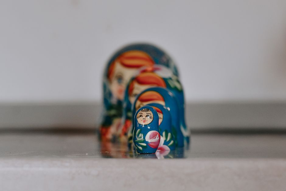 Close-up of colorful Russian nesting dolls in a line on a surface.