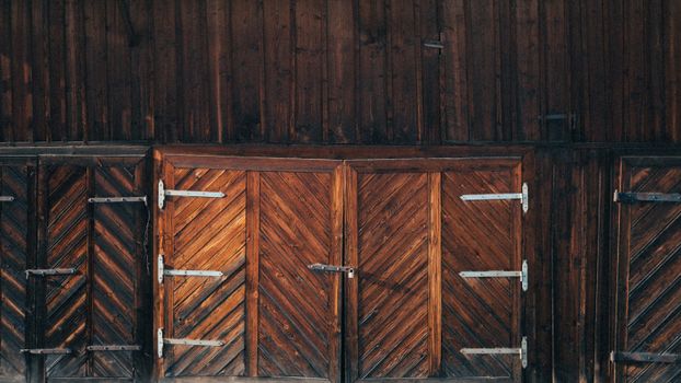 Detailed wooden barn doors with herringbone pattern and metal hinges.