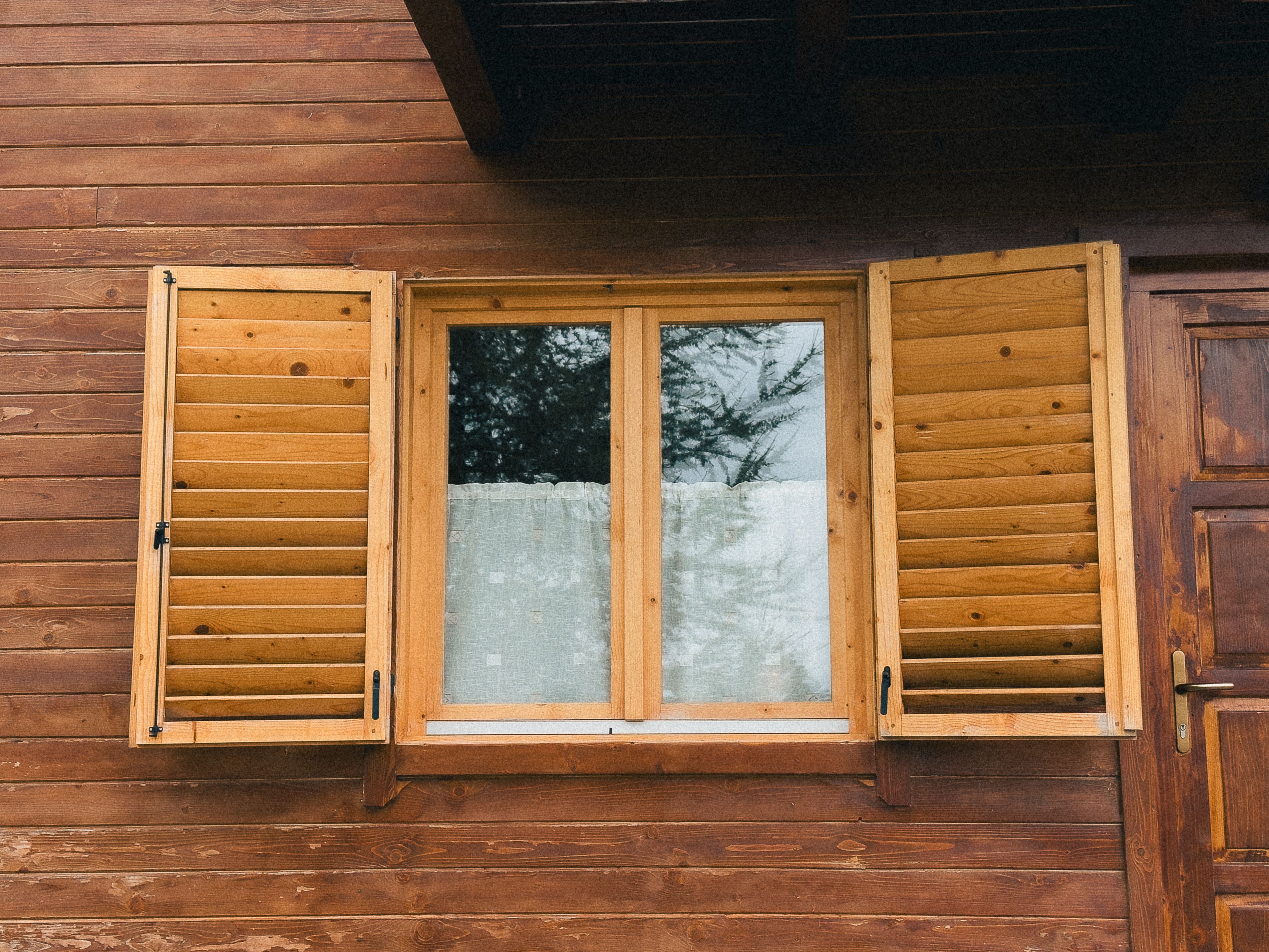 Free Image of a rustic wooden cabin window with open shutters showcasing natural textures. Stock Photo