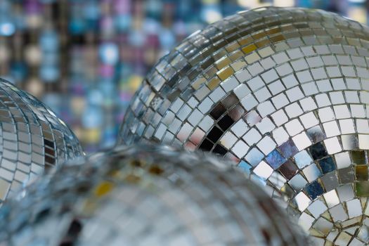 Vibrant close-up of disco balls reflecting colorful lights, creating a festive ambiance.