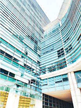 A towering modern glass skyscraper with reflective windows and unique architectural design.