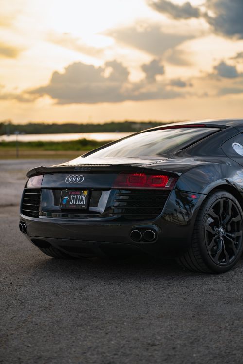 Free A sleek black car parked during a vibrant sunset, exuding elegance and power. Stock Photo