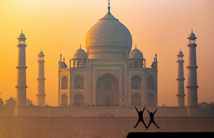 Silhouette Of Jumping Up People In Front Of Taj Mahal Mosque During Sunset 