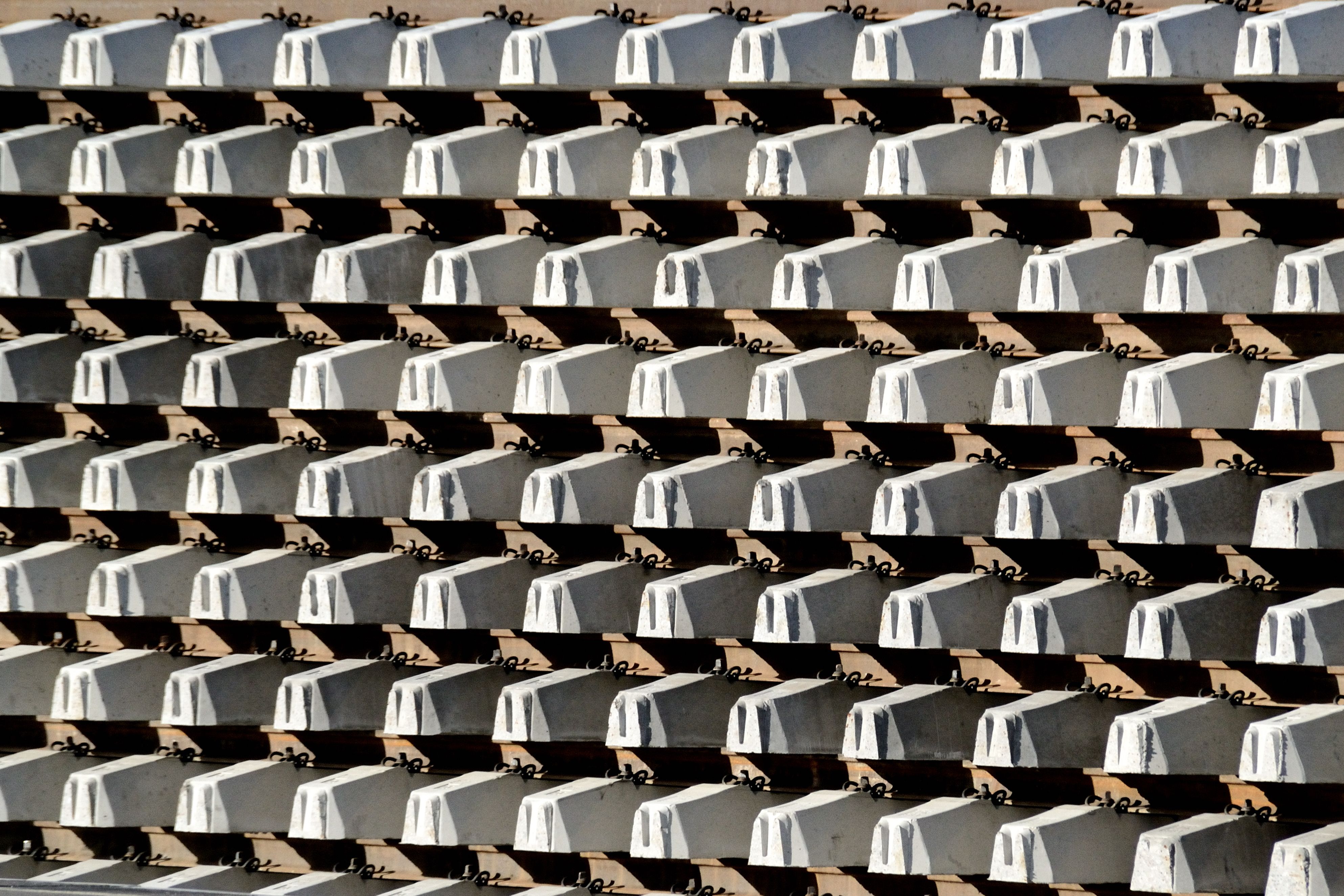 A geometric pattern of concrete blocks with shadows creating a symmetrical and industrial design effect.